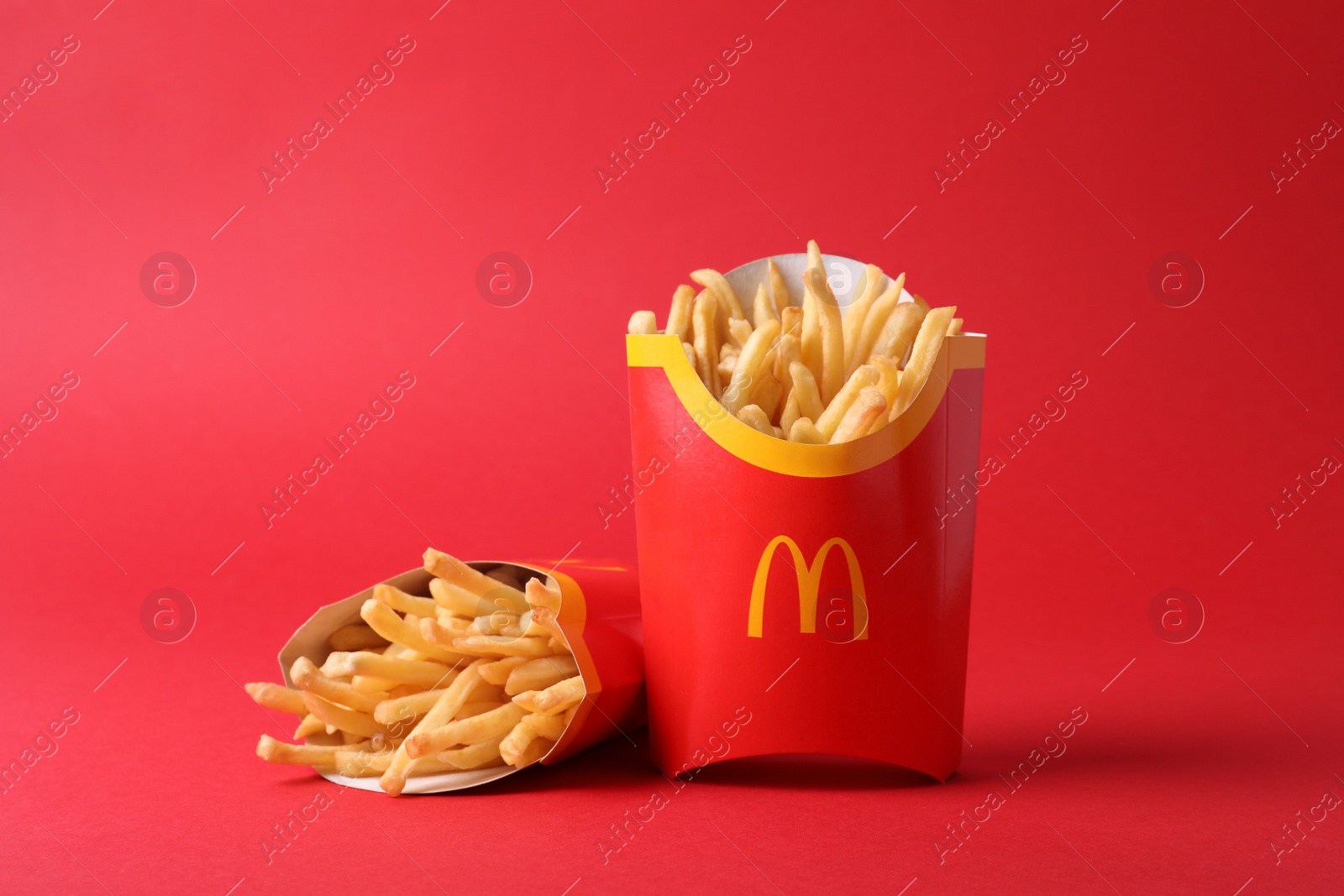 Photo of MYKOLAIV, UKRAINE - AUGUST 12, 2021: Two big portions of McDonald's French fries on red background