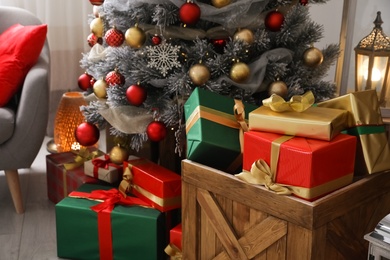 Photo of Wooden crate with gift boxes and Christmas tree in festive room interior