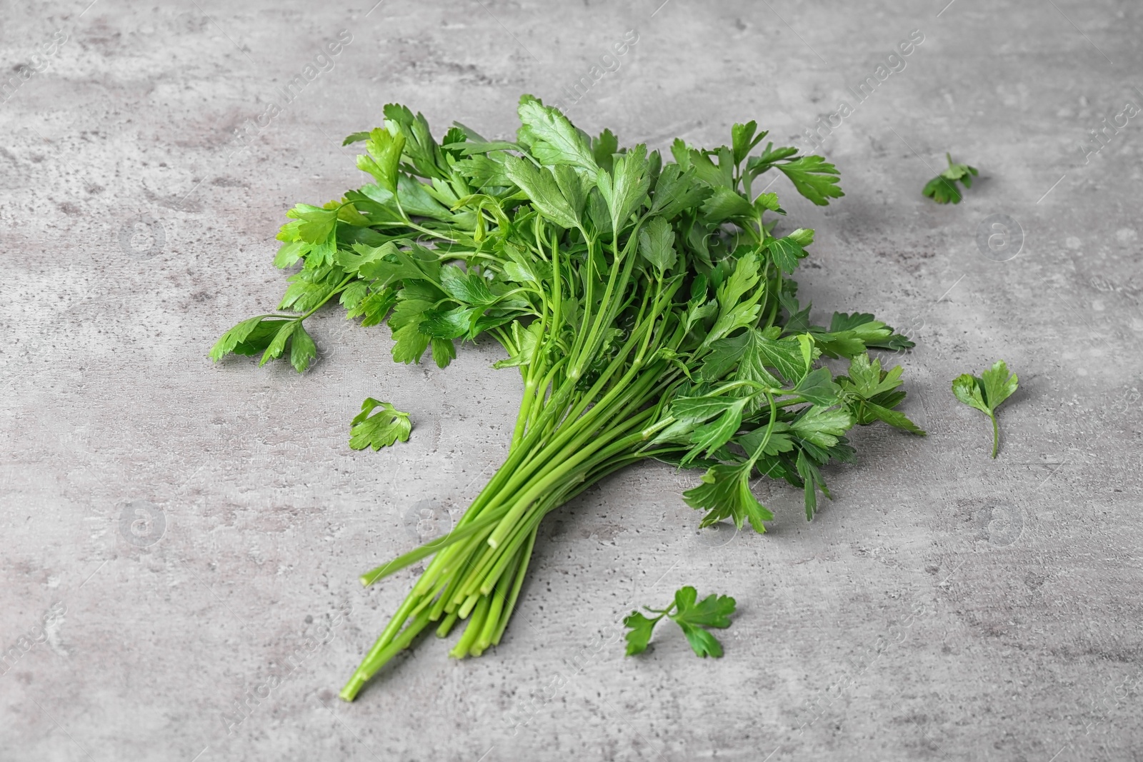 Photo of Bunch of fresh green parsley on grey background