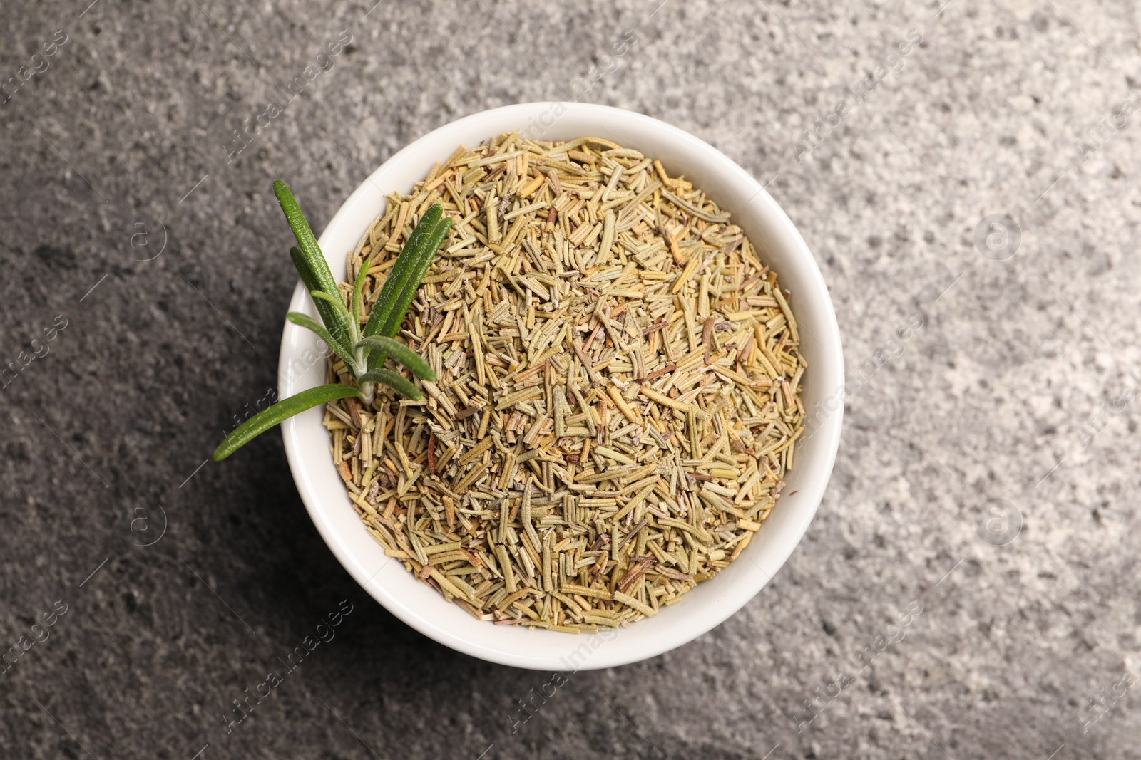 Photo of Dry and fresh rosemary in bowl on gray table, top view