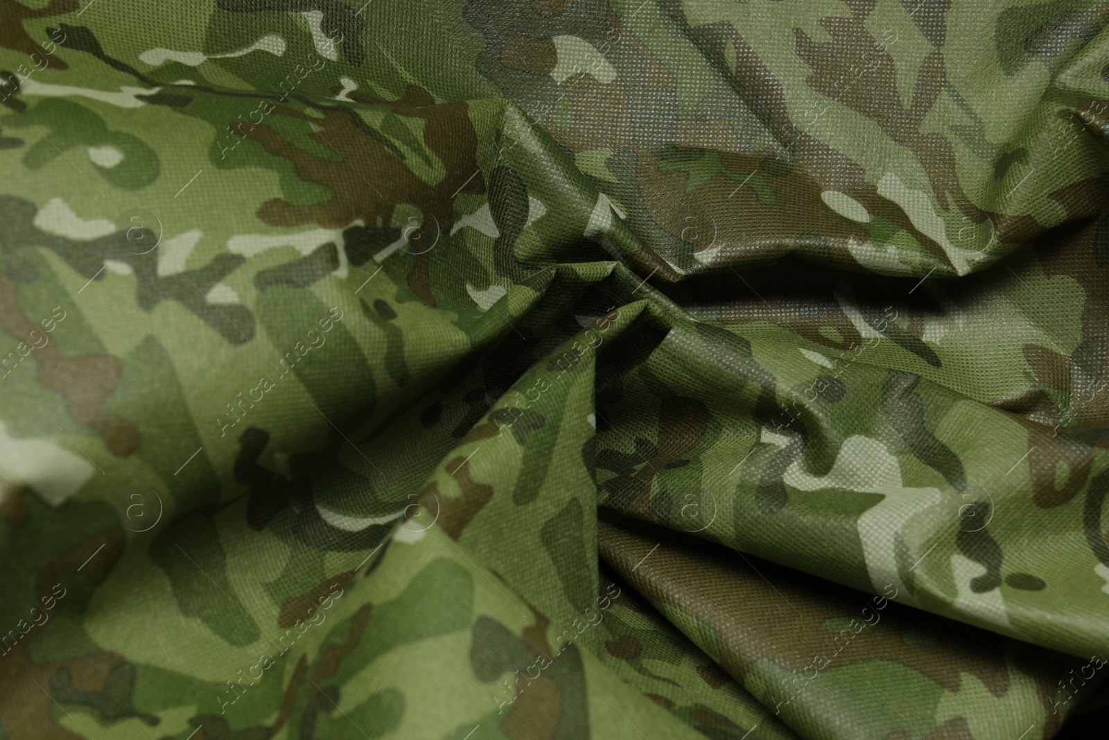 Photo of Texture of crumpled camouflage fabric as background, closeup