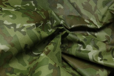 Texture of crumpled camouflage fabric as background, closeup