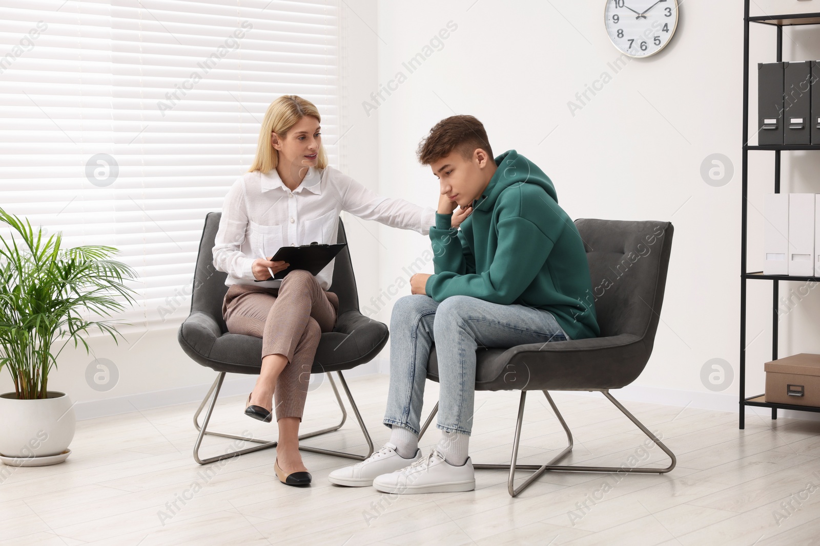 Photo of Psychologist working with teenage boy in office