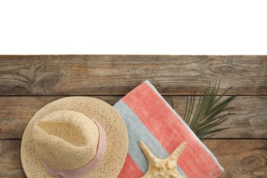 Photo of Wooden surface with beach towel and straw hat on white background, top view