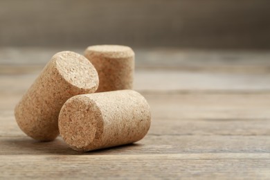 Photo of Corks of wine bottles on wooden table, closeup. Space for text