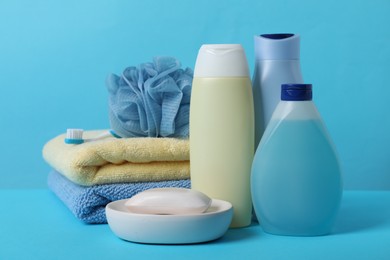Photo of Baby cosmetic products, accessories and towels on light blue background