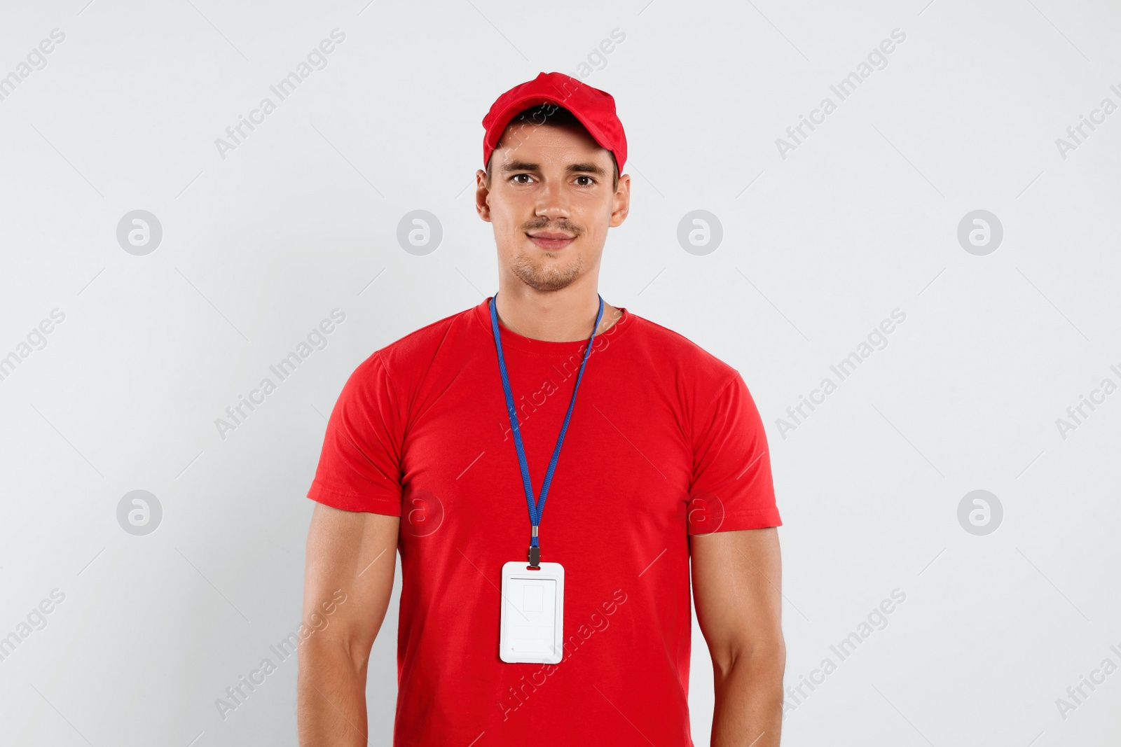 Photo of Portrait of happy young courier on white background