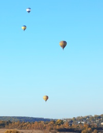 Photo of Colorful hot air balloons flying over countryside