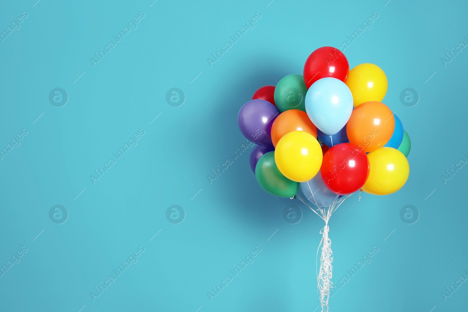 Photo of Bunch of bright balloons and space for text against color background