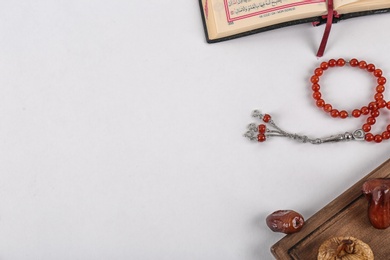 Flat lay composition with Muslim prayer beads, Quran and space for text on white background