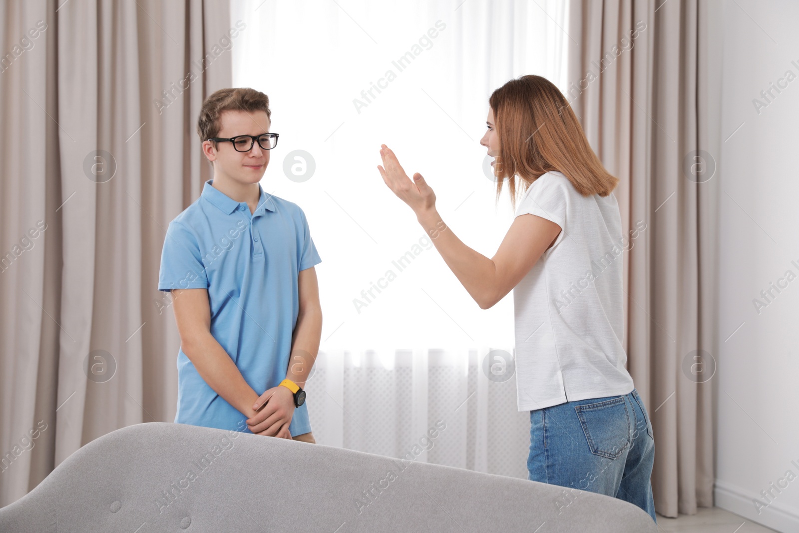 Photo of Mother scolding her teenager son at home