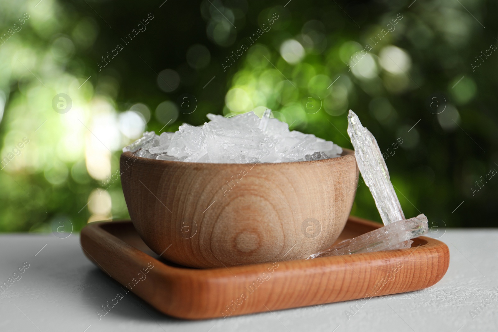 Photo of Menthol crystals on white table against blurred background