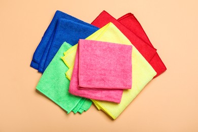 Photo of Many colorful microfiber cloths on beige background, flat lay