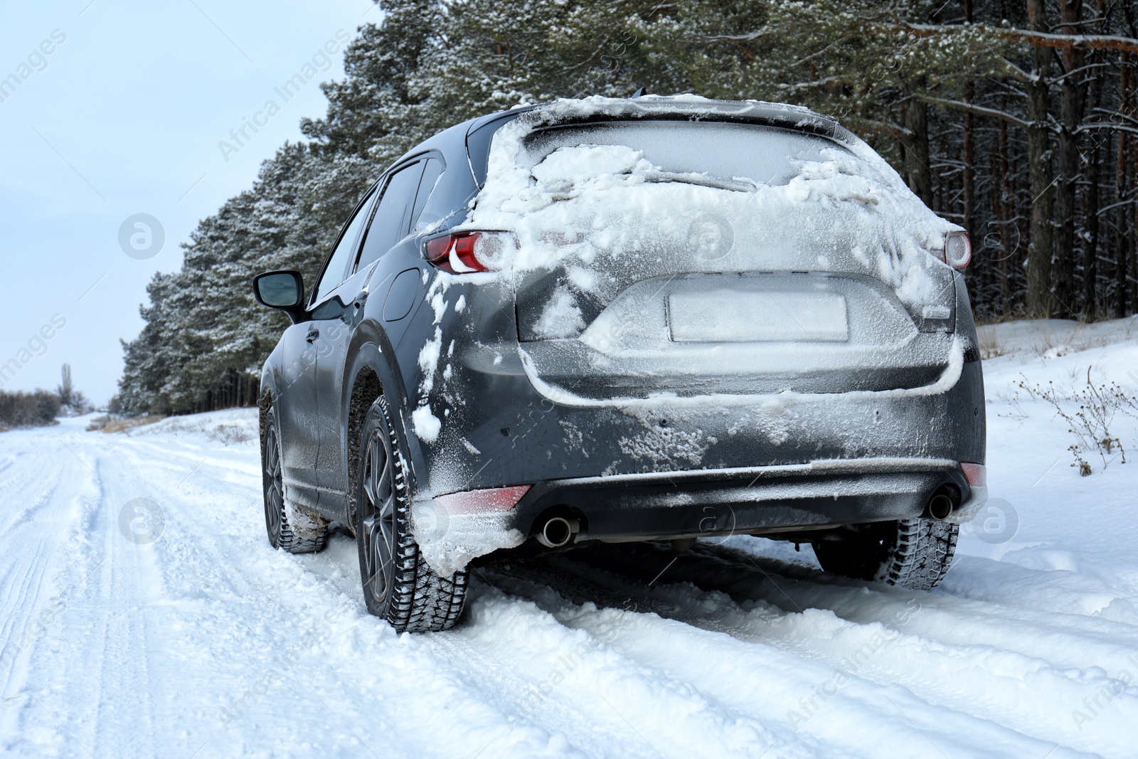 Photo of Snowy country road with car on winter day