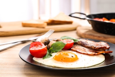 Photo of Tasty breakfast with fried egg on wooden table, closeup