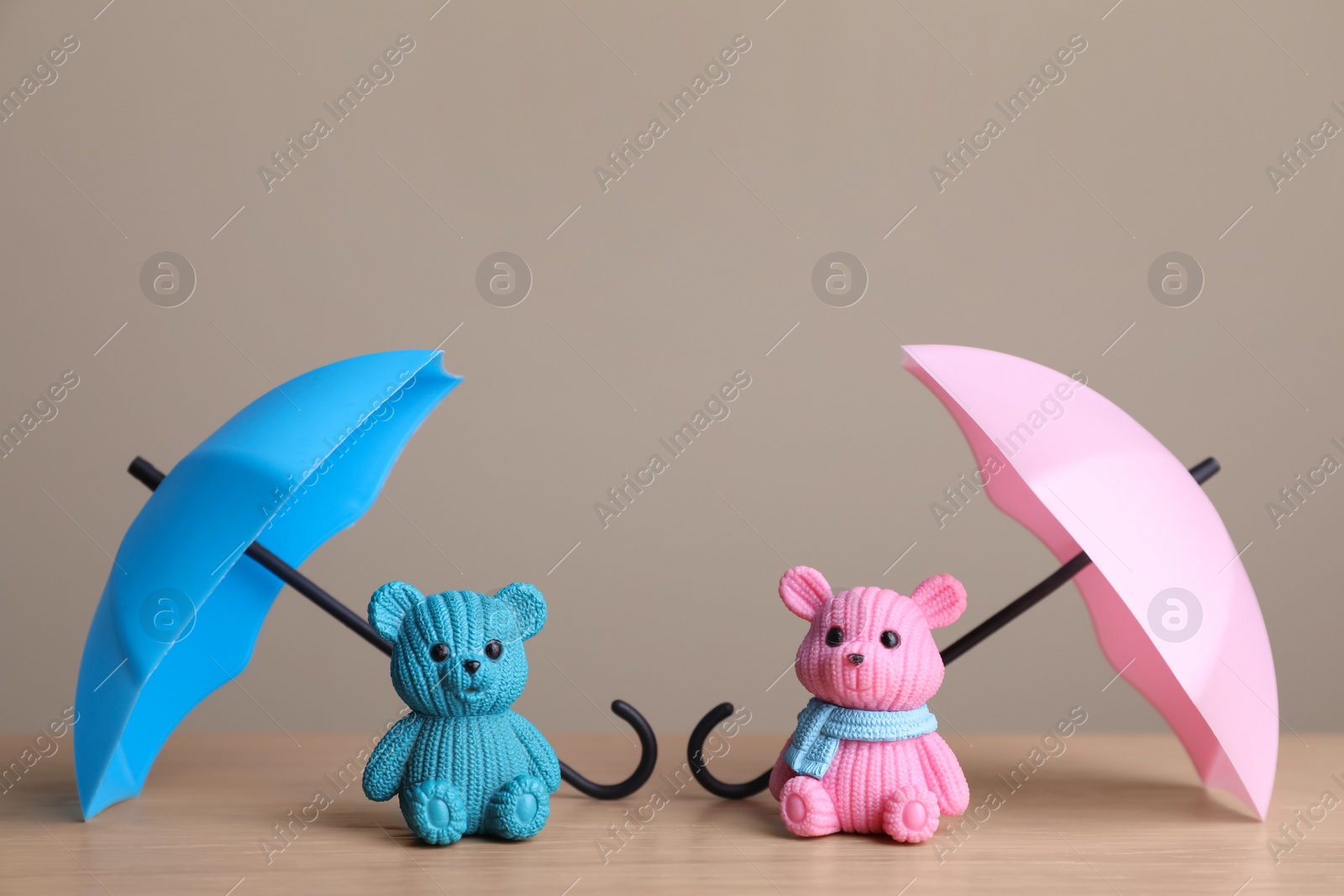 Photo of Small umbrellas and toy bears on wooden table