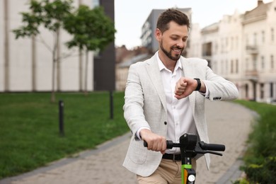 Photo of Businessman with modern kick scooter on city street, space for text