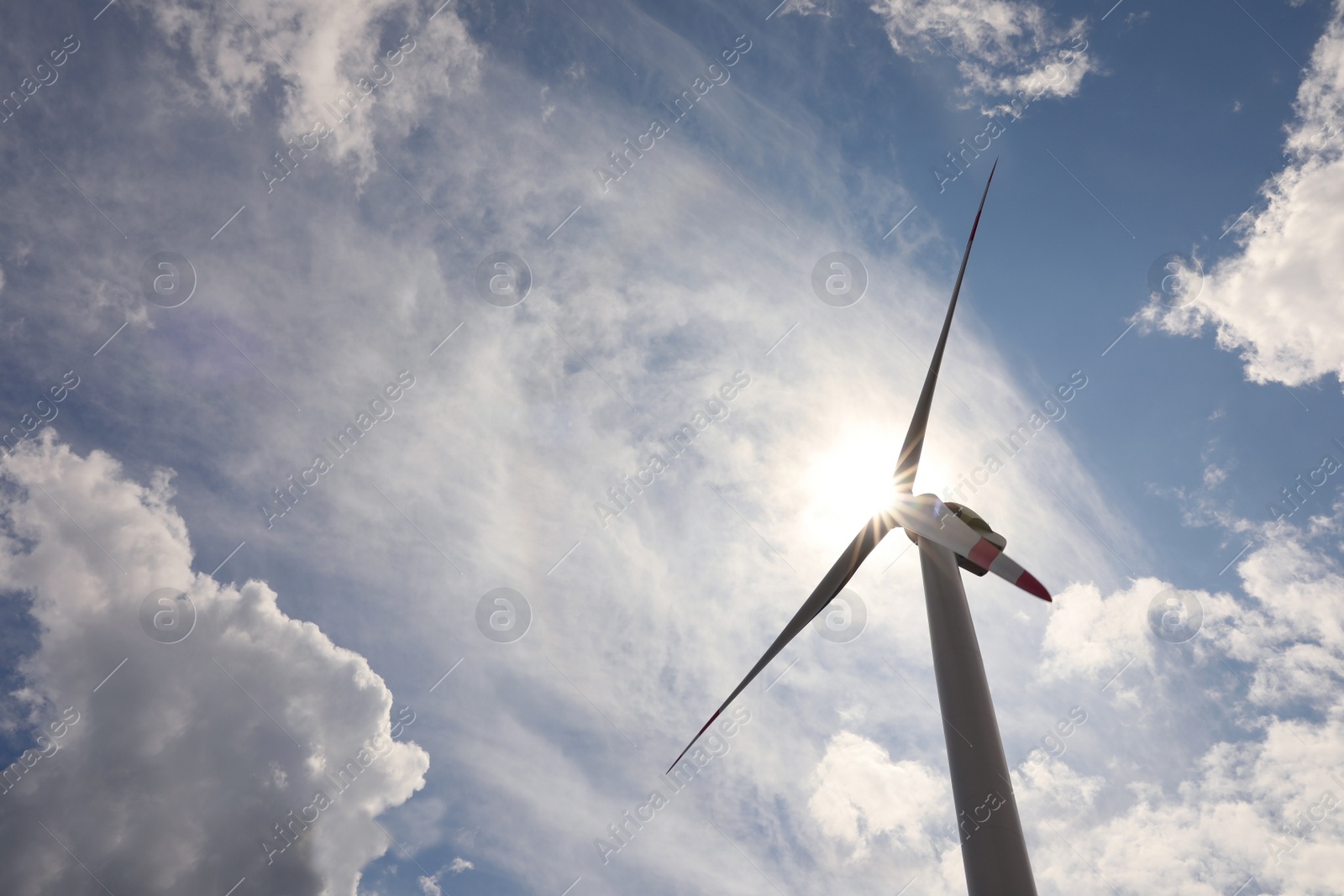 Photo of Modern wind turbine against cloudy sky, low angle view. Alternative energy source