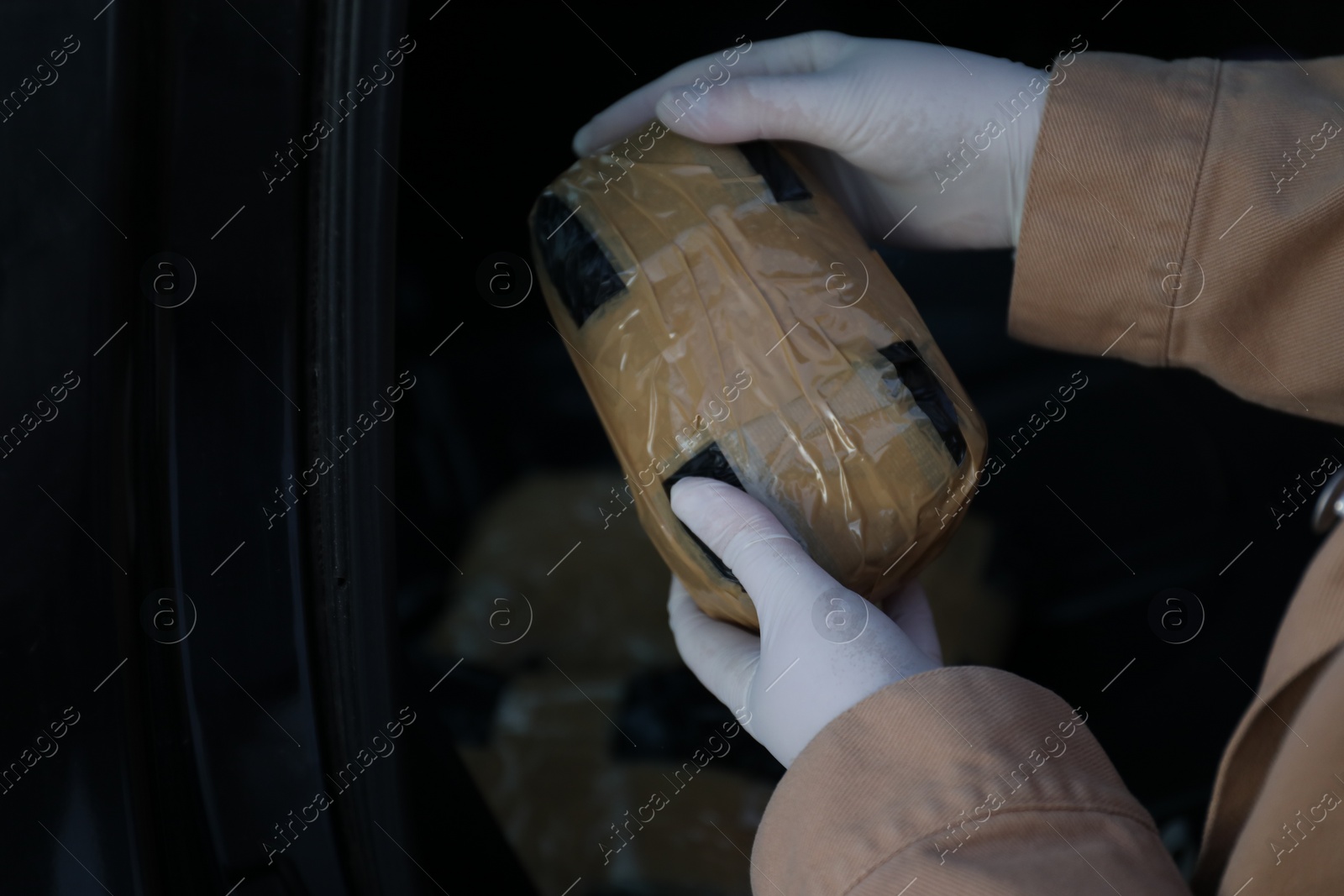 Photo of Man with package of narcotics on dark background, closeup. Space for text
