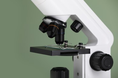 Photo of Modern microscope on green background, closeup. Medical equipment