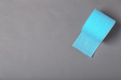 Roll of toilet paper on grey background, top view. Space for text