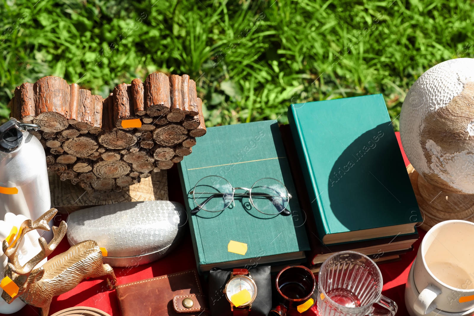 Photo of Many different items on table outdoors, above view. Garage sale