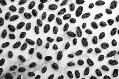 Photo of Flat lay composition with raisins on marble background. Dried fruit as healthy snack