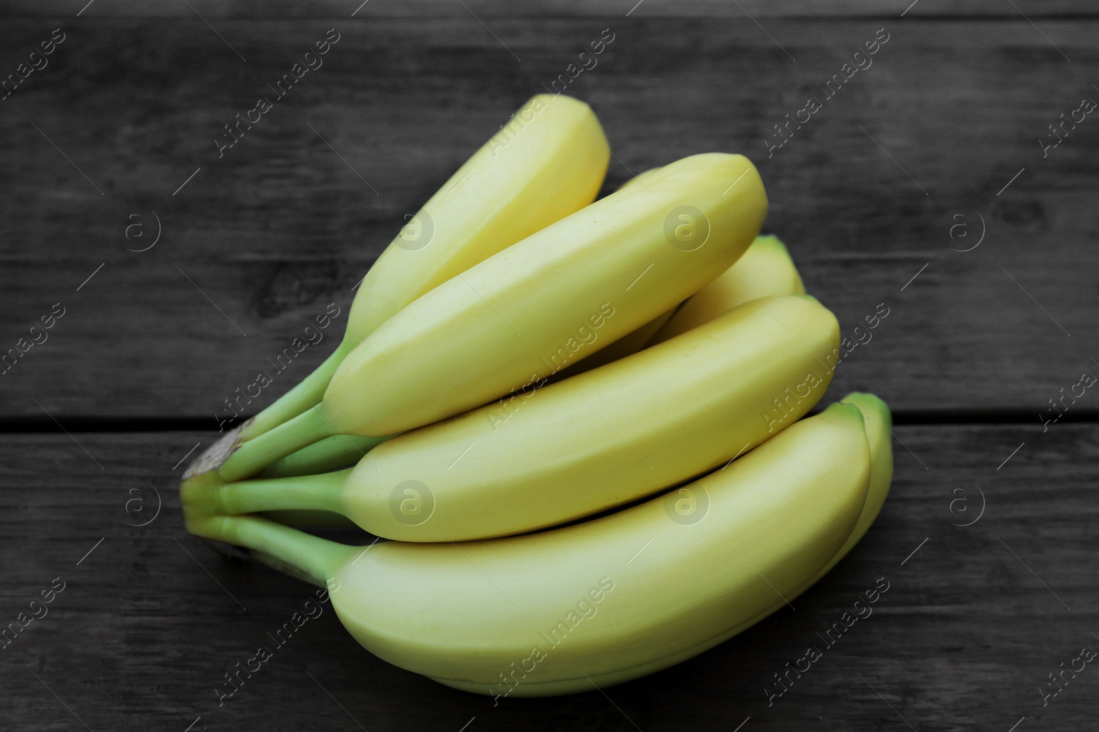 Photo of Bunch of ripe yellow bananas on wooden table