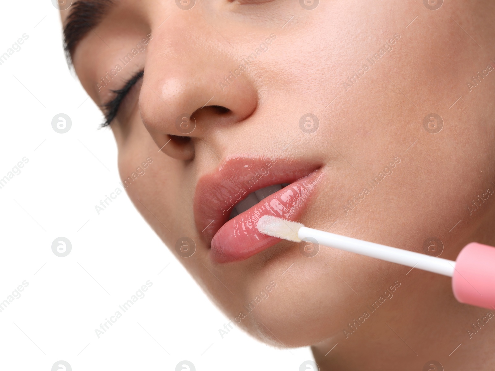 Photo of Woman applying lip gloss on white background, closeup