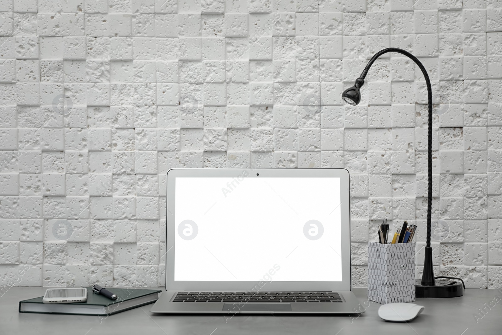 Photo of Laptop on desk against light wall in home office. Comfortable workplace