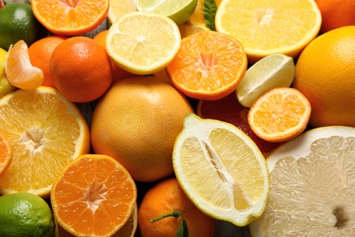 Different citrus fruits as background, top view