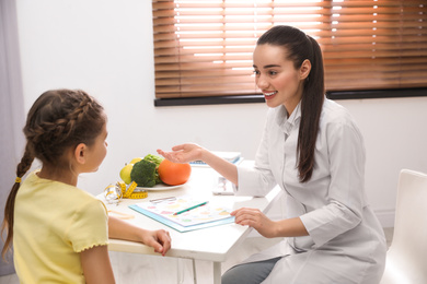 Photo of Little girl visiting professional nutritionist in office