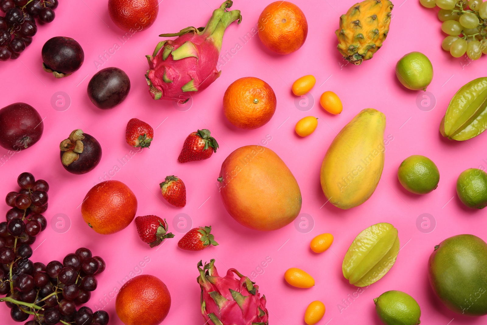 Photo of Many different delicious exotic fruits on pink background, flat lay