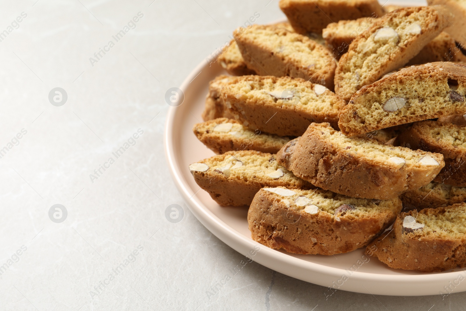 Photo of Traditional Italian almond biscuits (Cantucci) on light marble table, closeup. Space for text