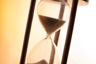 Hourglass with flowing sand on light background. Time management