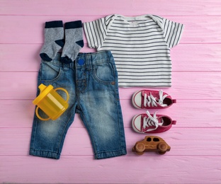 Flat lay composition with cute clothes on wooden background. Baby accessories