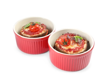 Baked eggplant with tomatoes, cheese and basil in ramekins isolated on white