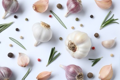 Fresh garlic, rosemary and peppercorns on white background, flat lay