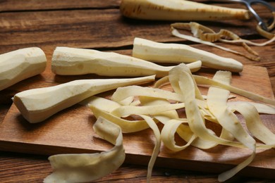 Photo of Peeled fresh parsnips and strips on wooden table