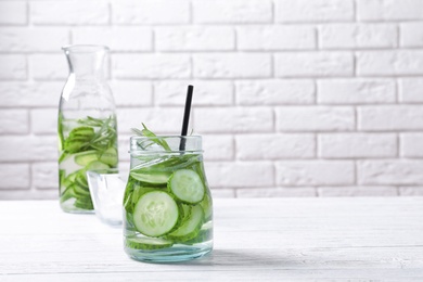 Photo of Natural lemonade with cucumber and rosemary in glassware on table