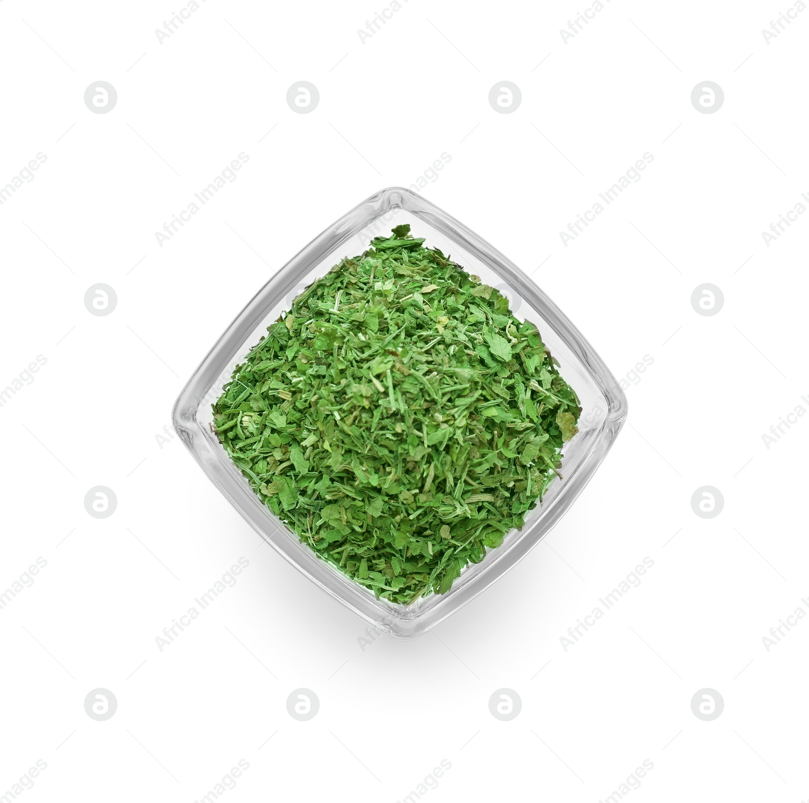 Glass bowl of dried parsley isolated on white, top view Photo of Glass bowl of dried parsley isolated on white, top view