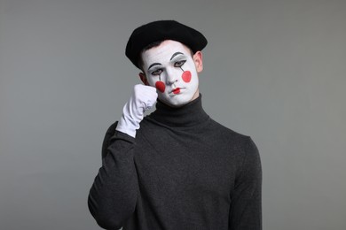 Photo of Portrait of mime artist in beret on grey background
