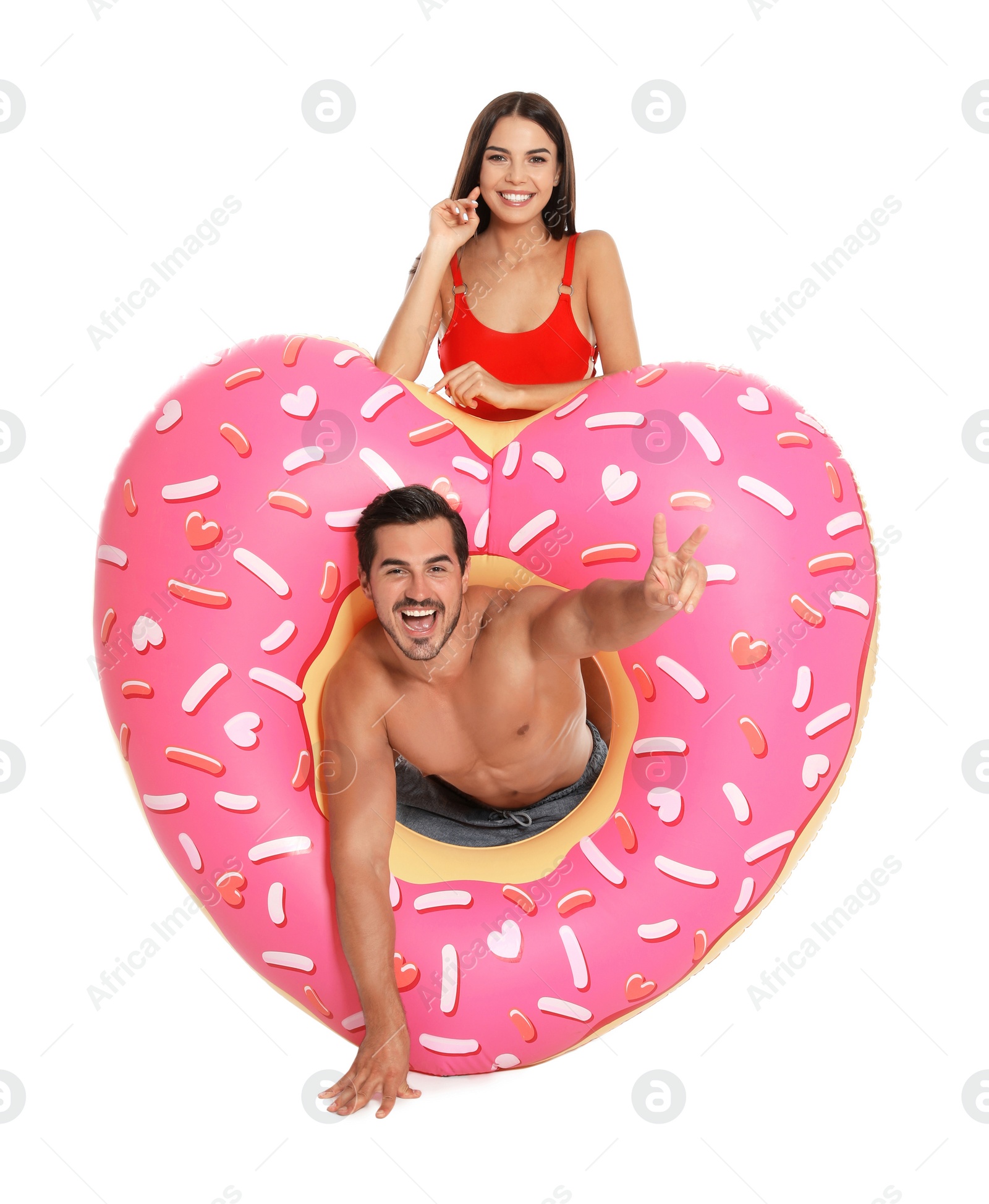 Photo of Young attractive couple in beachwear with inflatable ring on white background