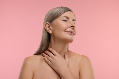 Beautiful woman with healthy skin on pink background