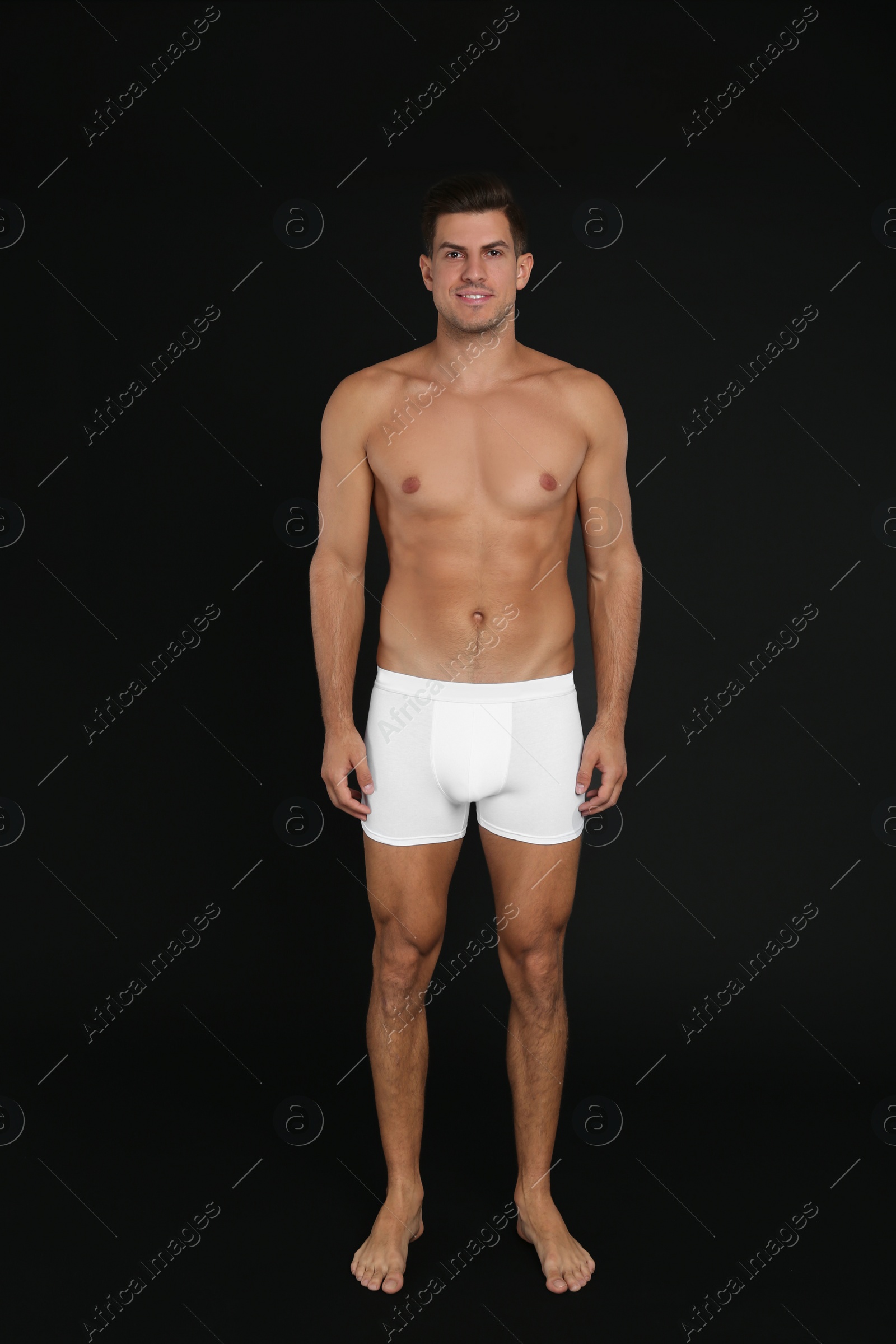 Photo of Handsome man in underwear on black background