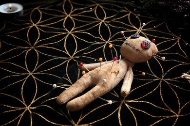 Voodoo doll pierced with pins on table. Curse ceremony