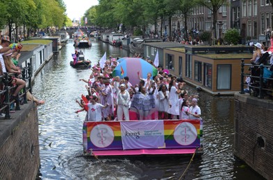 AMSTERDAM, NETHERLANDS - AUGUST 06, 2022: Many people in boats at LGBT pride parade on river