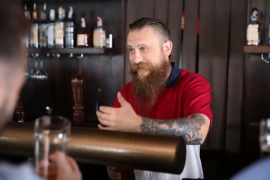 Bartender working at beer tap in pub