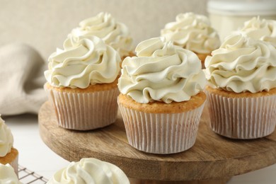 Photo of Tasty vanilla cupcakes with cream on white table, closeup