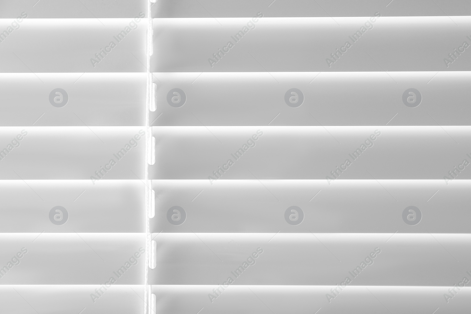 Photo of Closed modern white window blinds as background, closeup view